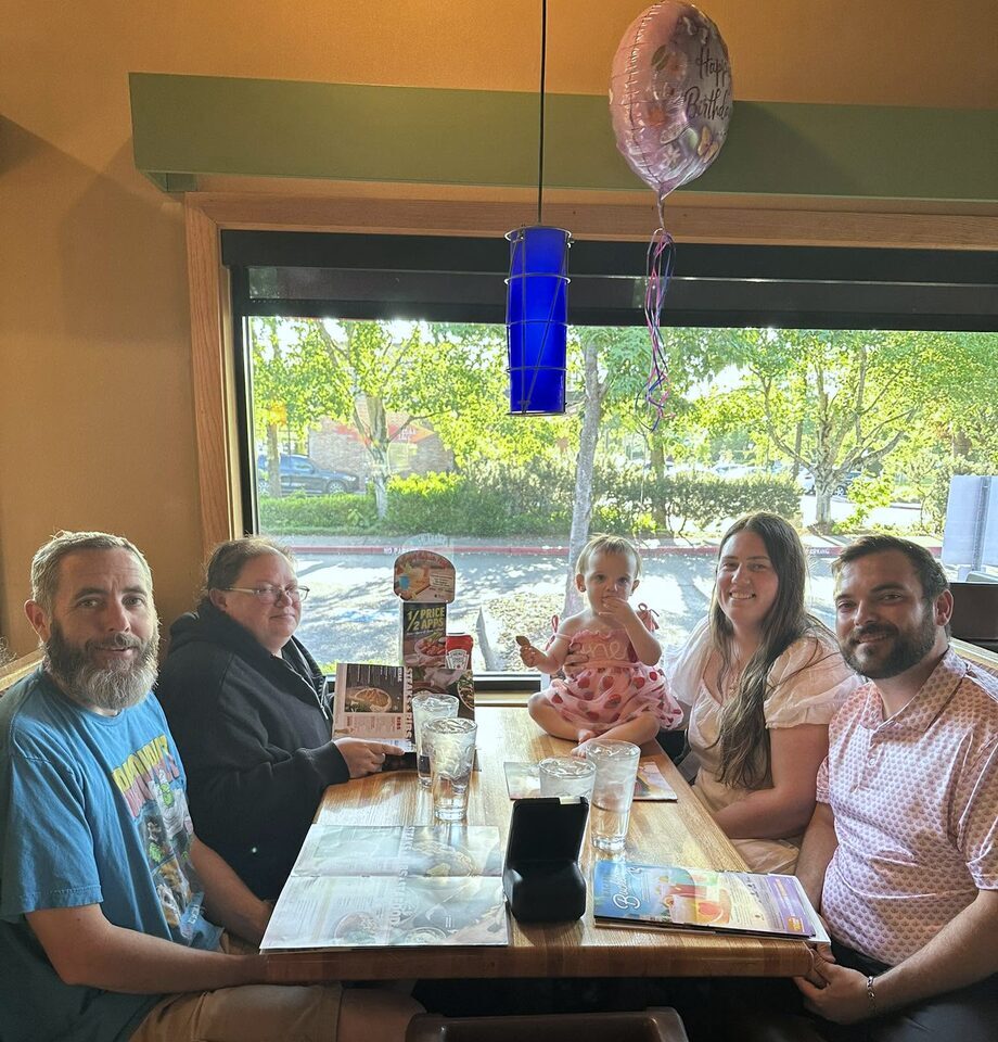 Tristen Ensign, owner of Shoreline Pro Services, with his family around a restaurant table