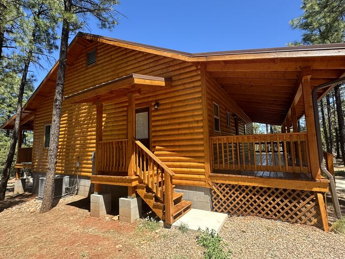 Log cabin front porch and entry after exterior wood staining