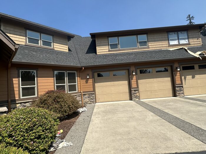 Craftsman-style home exterior repaint in Clark County WA, amber siding with dark brown trim, 3-car garage