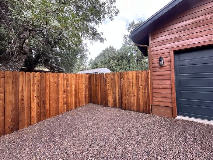 Fence corner and house siding after deck and fence staining project