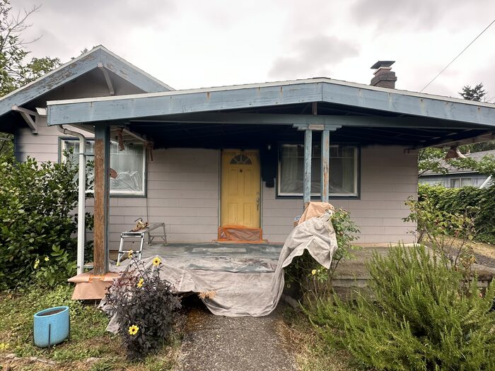 Vancouver WA home exterior before repaint, weathered gray siding and peeling blue trim on covered porch